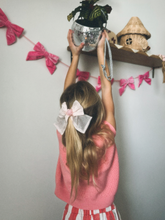 Load image into Gallery viewer, Child reaching for a disco ball on a shelf with decorative bows on the wall.
