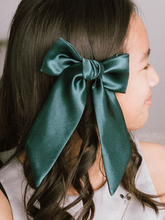 Load image into Gallery viewer, Person with a large green bow in their hair
